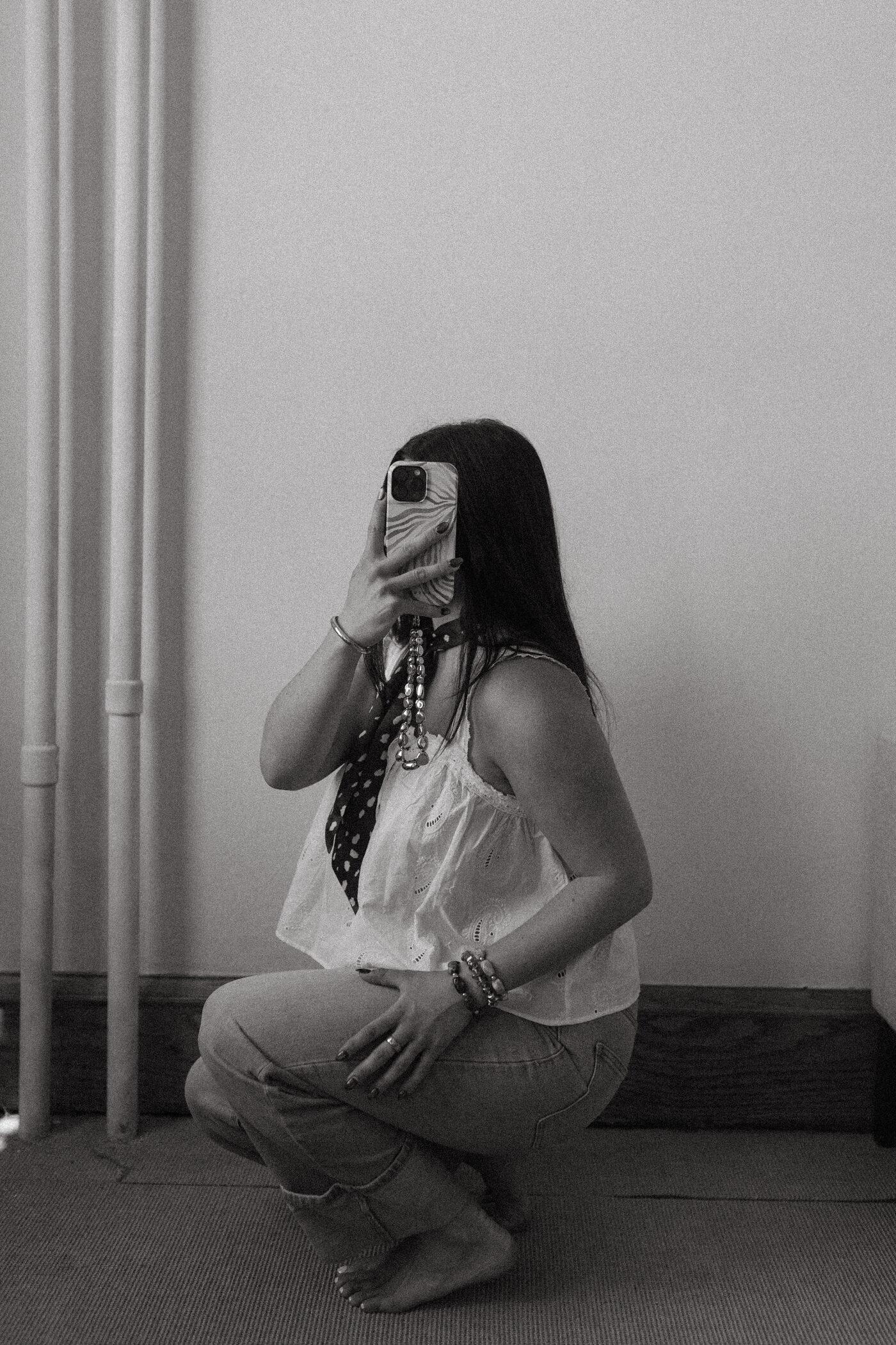 Black and white photo of Morgan Bartow filming on her phone